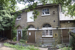 Photo of the dilapidated stable block with windows visible